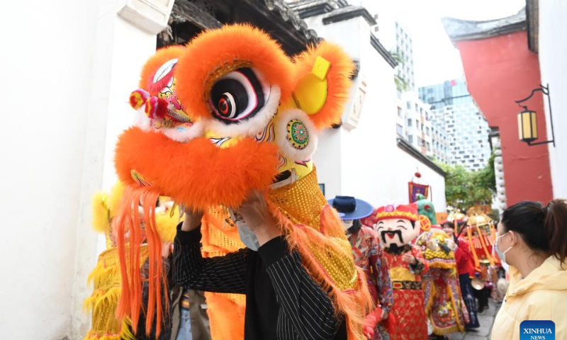 People take part in a parade welcoming the God of Wealth at Sanfangqixiang (Three Lanes and Seven Alleys), an ancient block in downtown Fuzhou, southeast China's Fujian Province, Jan. 26, 2023. Ceremonies were held to welcome the God of Wealth as a tradition on the fifth day of the Chinese Lunar New Year, which falls on Thursday this year. Photo: Xinhua