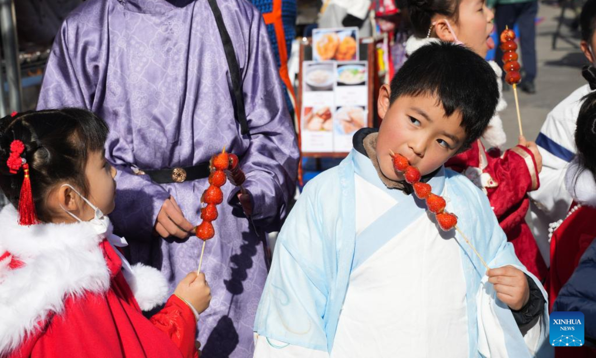 Children in costumes eat Tanghulu, a traditional Chinese snack of candied fruit, during the 17th Nagoya Chinese New Year Festival in Nagoya, Japan, on Jan 6, 2023. Photo:Xinhua