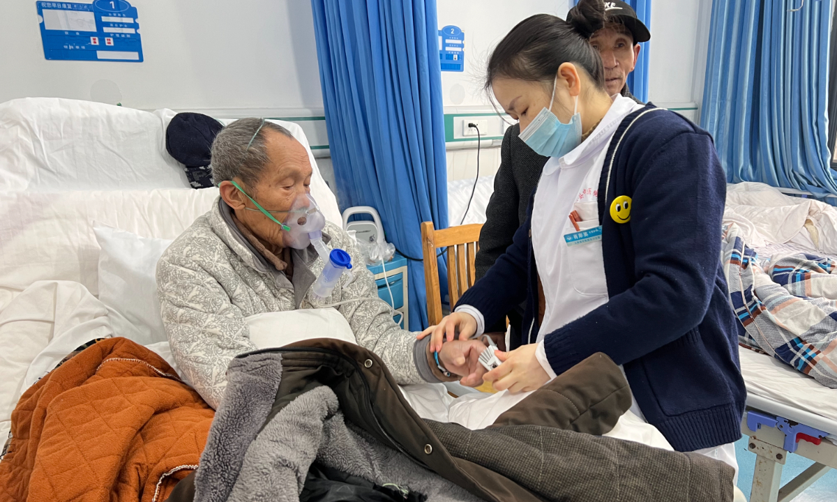 A nurse in Shuikou township hospital in Chongqing checks the blood oxygen of a COVID-19 patient. Photo: Zhao Yusha/GT