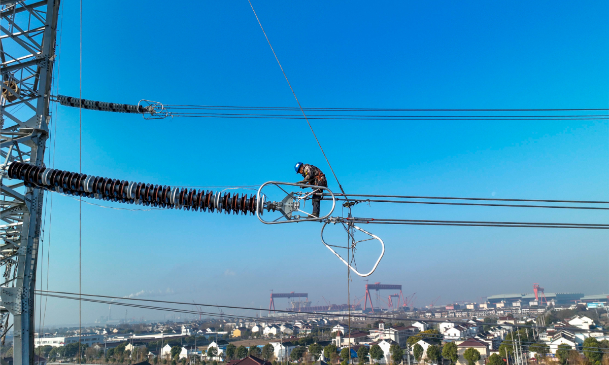 A worker conducts aerial operations on a 500-kilovolt transmission line project in Jingjiang, East China's Jiangsu Province, on January 11, 2023. The project, which can meet the daily power demand of about 8 million households, is about to be completed. Photo: VCG