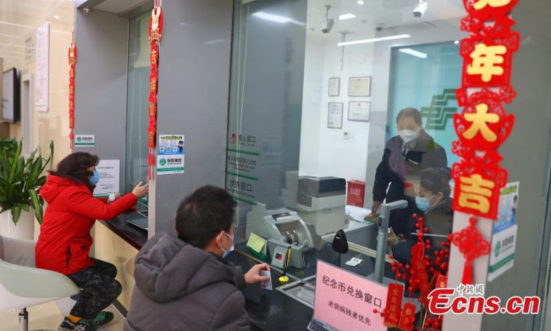 People exchange commemorative coins for the Year of the Rabbit at the Jiangxi branch of the Postal Saving Bank of China in Nanchang, east China's Jiangxi Province, Jan. 5, 2023. (Photo: China News Service/Liu Zhankun)