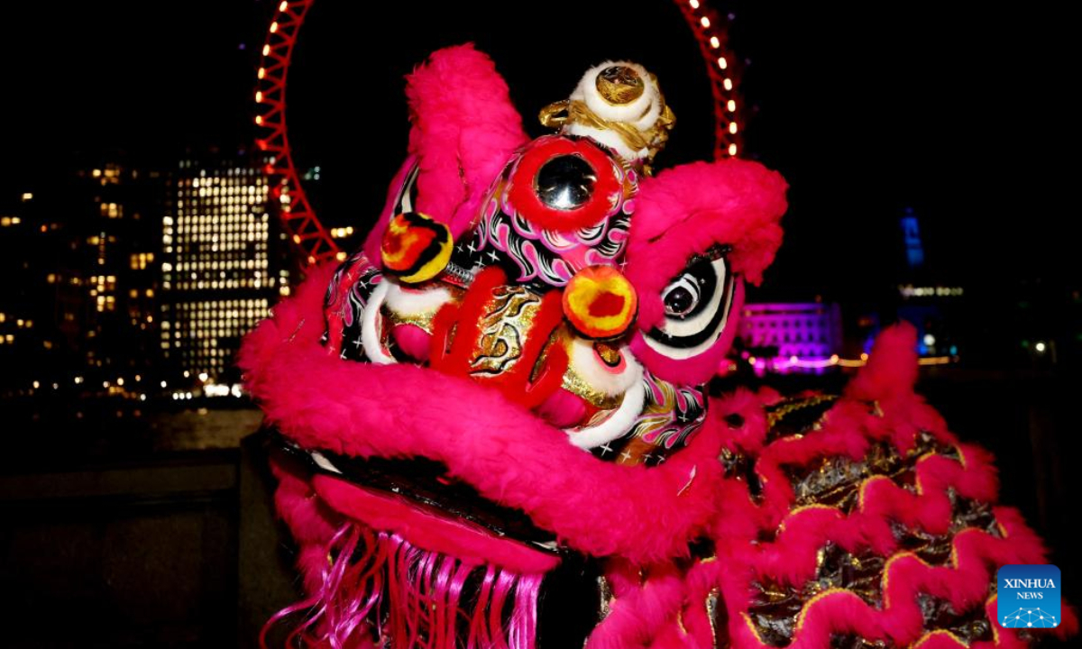 Traditional Chinese lion dancers perform in front of the London Eye which is lit up in red to celebrate the upcoming Chinese New Year in London, Britain, Jan 13, 2023. Photo:Xinhua
