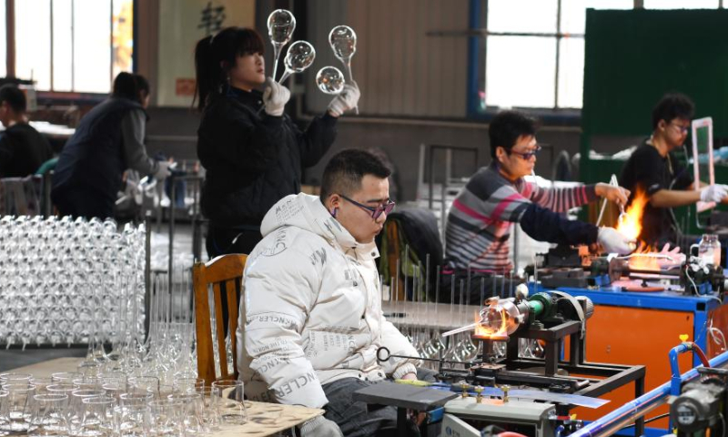 Workers make glasswork at the workshop of a company in Hejian City, north China's Hebei Province, Feb. 11, 2023. Hejian City is famous for its glasswork making industry. Now, there are more than 200 glasswork making companies and over 60,000 staff members involved in the industry in Hejian. The annual output of the glasswork reached nearly 10 billion yuan (about 1.47 billion U.S. dollars) and the glasswork has been exported to over 50 countries and regions. Photo: Xinhua