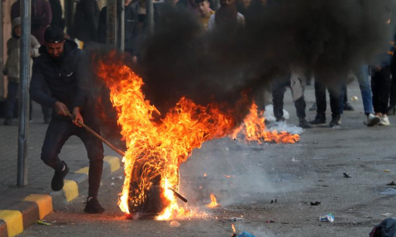 A Palestinian protester rolls a burning tire during clashes with Israeli soldiers in the West Bank city of Hebron, on Jan. 26, 2023. Israeli forces killed on Thursday at least nine Palestinians, including an elderly woman, during a raid in the occupied West Bank, Palestinian sources said, amid escalating violence in the region. Photo: Xinhua