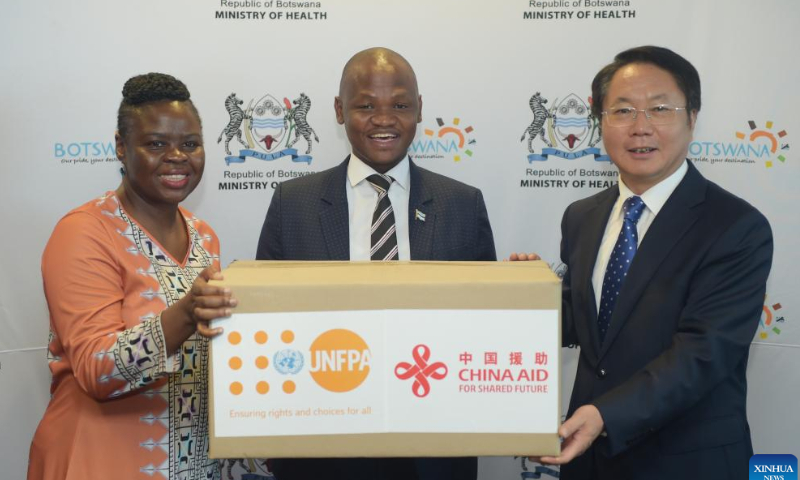 Botswana Health Minister Edwin Dikoloti (C), Chinese Ambassador to Botswana Wang Xuefeng (R) and a UNFPA official pose for a group photo during the handover ceremony of personal protective equipment and reproductive health products donated by China in Gaborone, Botswana on Jan. 27. 2023. China on Friday donated personal protective equipment (PPE) and reproductive health products to Botswana. Photo: Xinhua