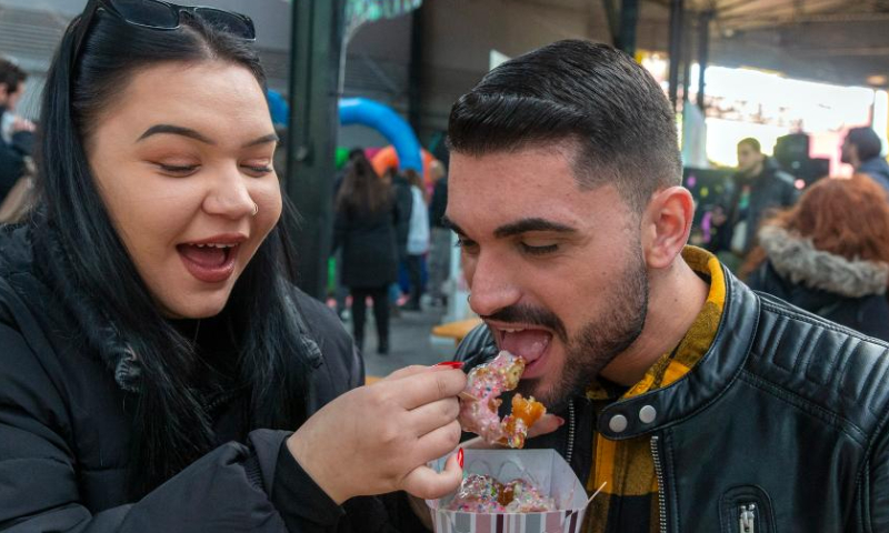 Visitors enjoy snacks at the 4th Chocolate Fest in Athens, Greece, Feb. 11, 2023. Photo: Xinhua