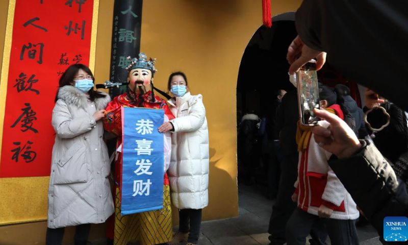 A staff member in the costume of the God of Wealth poses for photos with tourists at a scenic spot in Suzhou, east China's Jiangsu Province, Jan. 26, 2023. Ceremonies were held to welcome the God of Wealth as a tradition on the fifth day of the Chinese Lunar New Year, which falls on Thursday this year. Photo: Xinhua