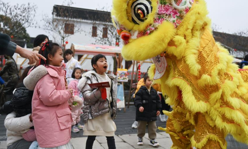Children interact with lion dance performers in Lucun Village of Balidian Town, Huzhou City, east China's Zhejiang Province, Feb. 5, 2023. People celebrate the Lantern Festival, the 15th day of the first month of the Chinese lunar calendar, with various traditional customs across the country. Photo: Xinhua