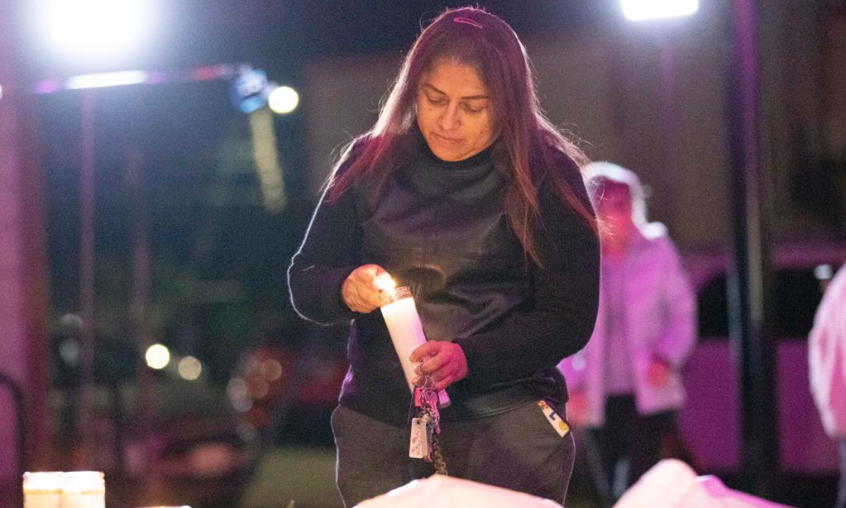 A woman lights a candle to mourn victims of the shootings in Half Moon Bay in California, the United States, Jan 24, 2023. Photo:Xinhua