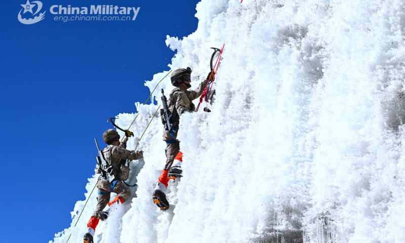 Soldiers assigned to a PLA army brigade stationed in Xizang climb up a cliff covered by thick ice layer with professional climbing equipment such as pickaxes and nailed climbing boots during a reconnaissance training exercise on plateau in late December of 2022. Photo: eng.chinamil.com.cn