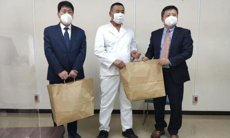 Cheng Yan (R), Chinese deputy consul-general in Fukuoka, and Guo Xuejing (L), a consul of the Chinese Consulate-General in Nagasaki, hand daily life supplies to a rescued Chinese crew member in Nagasaki, Japan, Jan. 26, 2023. Eight crew members of a cargo ship that sank off southwestern Japan have been confirmed dead, including six Chinese nationals, said the Chinese Consulate-General in Fukuoka on Thursday. Photo: Xinhua
