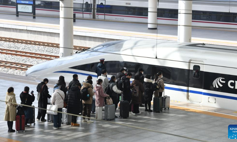 Passengers line up to borad a train at Fuyang West Railway Station in east China's Anhui Province, Jan. 27, 2023. Railway stations, highways and airports across China are bracing for a fresh travel peak as a growing number of travelers hit the road and return to work after a week-long Spring Festival holiday which ends on Friday. Photo: Xinhua