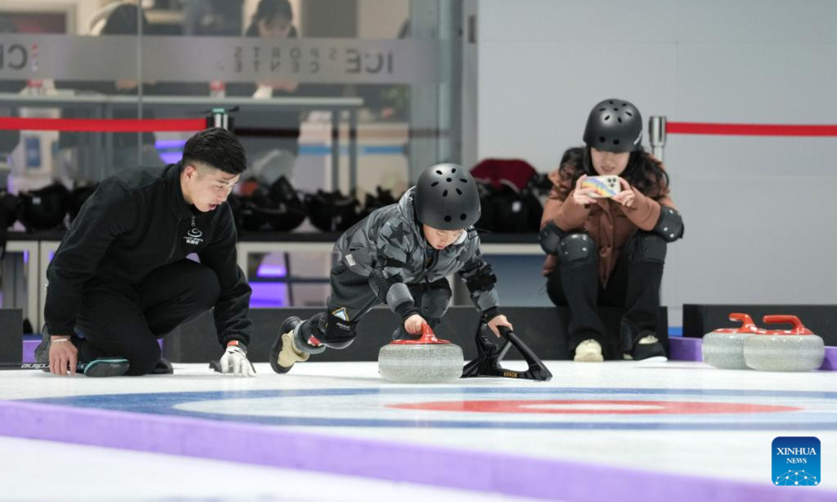 A child (C) practices curling at National Aquatics Centre in Beijing, capital of China, Feb 1, 2023. Photo:Xinhua