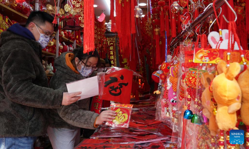 People select festive decorations for the Spring Festival at the Yuyuan market in east China's Shanghai Jan. 18, 2023. This year's Spring Festival, the Chinese traditional lunar New Year, starts from Jan. 22. (Xinhua/Liu Ying)