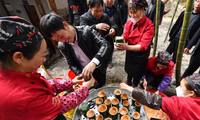 Local people teach villagers from Wuying Village to cook rice in bamboo, in Tongban hamlet of Dongqi Township in Rong'an County, south China's Guangxi Zhuang Autonomous Region, Feb. 18, 2023. Photo: Xinhua