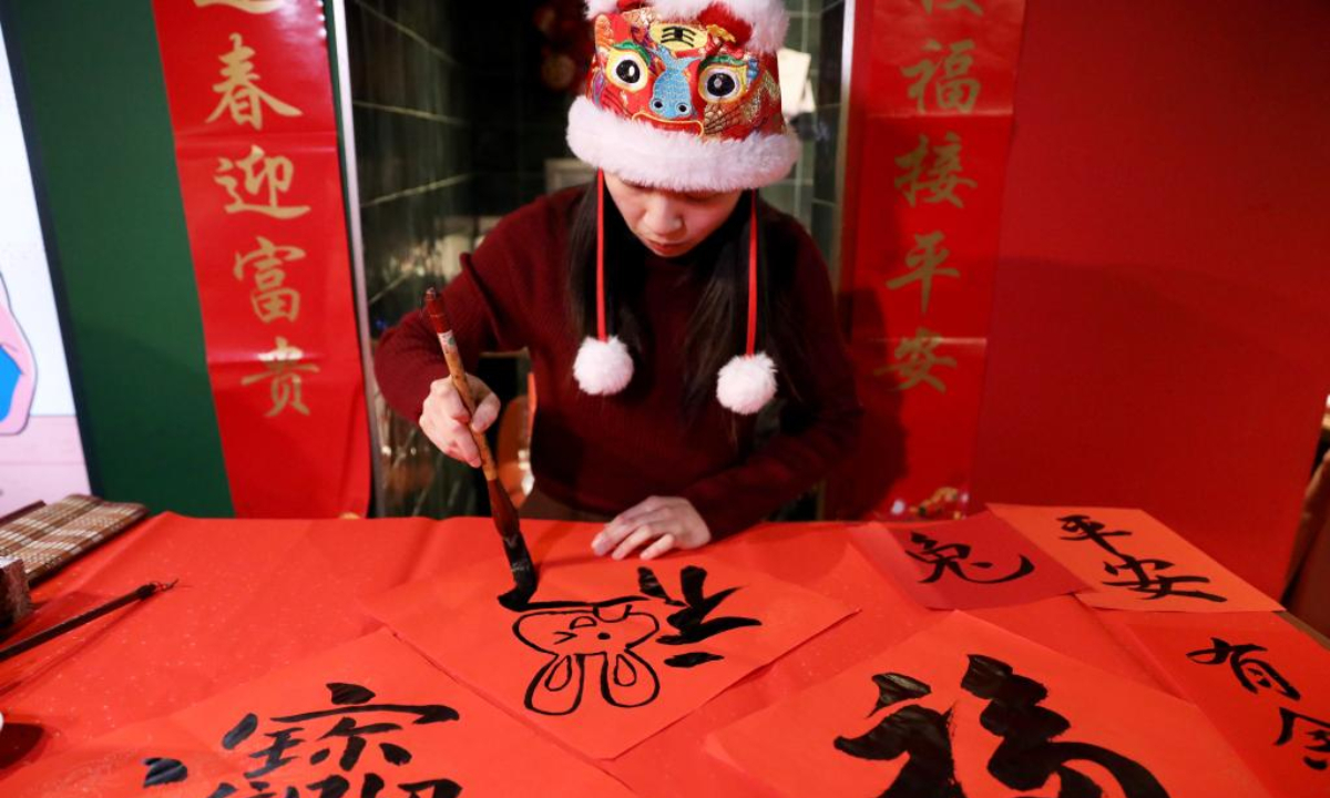 A woman writes Chinese calligraphy during Exploring Yummy Chongqing in London event in London, Britain, Feb 2, 2023. Photo:Xinhua