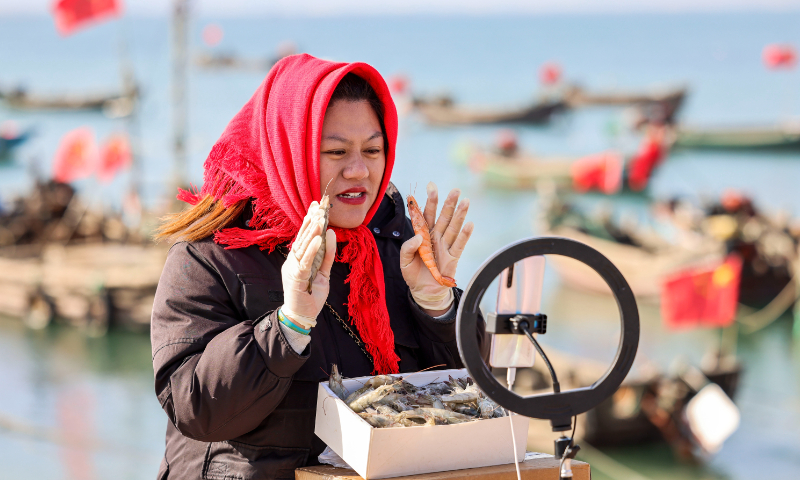 A broadcaster shows local prawns to consumers through livestreaming at a port in Dongshanzhang village, East China's Shandong Province on February 14, 2023. Oysters, prawns and other types of local seafood were sold live to customers nationwide on various online platforms. About 120 orders were made within two hours. Photo: cnsphoto