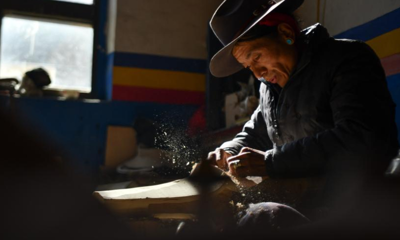 Sonam Chungla makes a Zhanian instrument in Lnaze County, southwest China's Tibet Autonomous Region, Jan. 19, 2023. Zhanian, a stringed instrument, is widely used in songs and dances in Tibet. In Tibetan language, Zhanian is the word for the melodious sound. Zhanian making has a long history and the making technique was listed as a national intangible cultural heritage in 2014. Living in Lnaze County, a place known for Zhanian making, the 47-year-old Sonam Chungla learned the skills from his father when he was 14 and became an inheritor of this intangible cultural heritage later. Sonam Chungla has always been committed to protecting and carrying forward the instrument-making techniques. He set up a cooperative with his friends in 2010 to produce Zhanian. With improved craft and financial support from local authorities, the cooperative runs well and Zhanian instruments they made are gaining popularity. (Xinhua/Jigme Dorje)