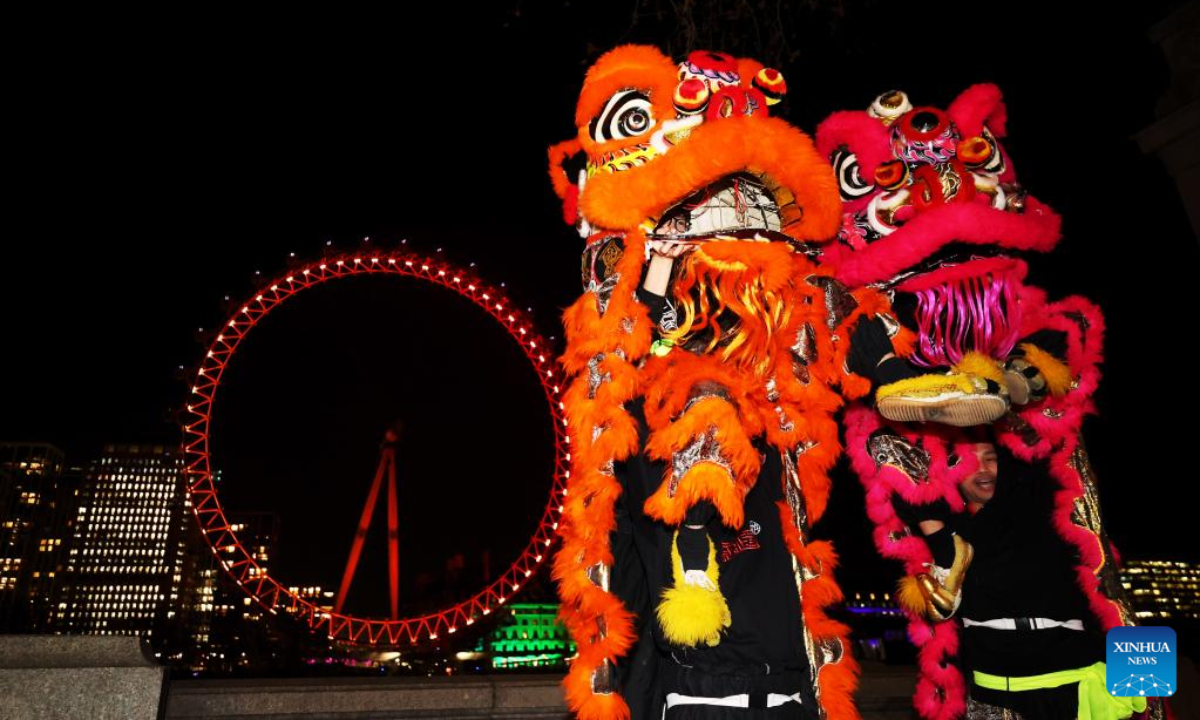 Traditional Chinese lion dancers perform in front of the London Eye which is lit up in red to celebrate the upcoming Chinese New Year in London, Britain, Jan 13, 2023. Photo:Xinhua