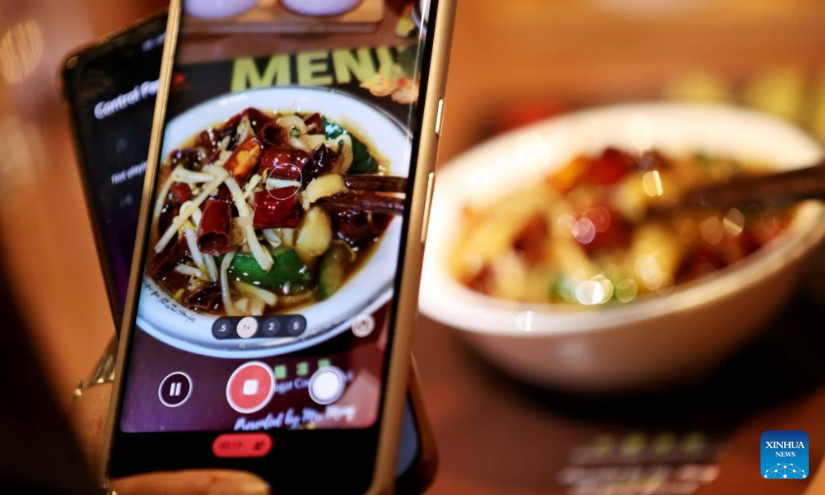 A customer takes photos of boiled spicy fish fillet during