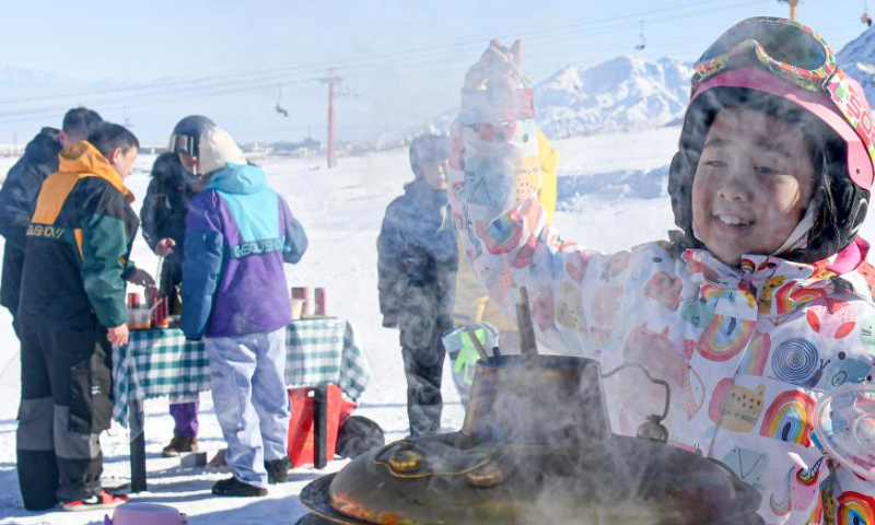 A girl waits to taste hot-pot dish at a ski resort in Urumqi County, northwest China's Xinjiang Uygur Autonomous Region, Jan. 13, 2023. Photo: Xinhua