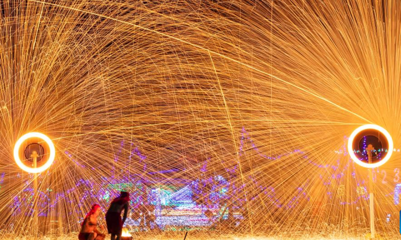 People enjoy iron flowers, a folk art performance of throwing molten iron to create fireworks, in Liushuigou Village of Huaying City, southwest China's Sichuan Province, Jan. 25, 2023. Photo: Xinhua