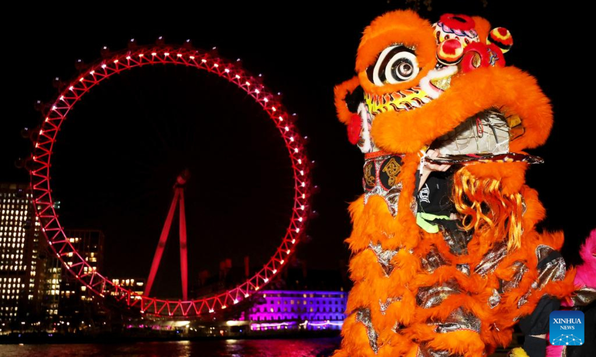 Traditional Chinese lion dancers perform in front of the London Eye which is lit up in red to celebrate the upcoming Chinese New Year in London, Britain, Jan 13, 2023. Photo:Xinhua