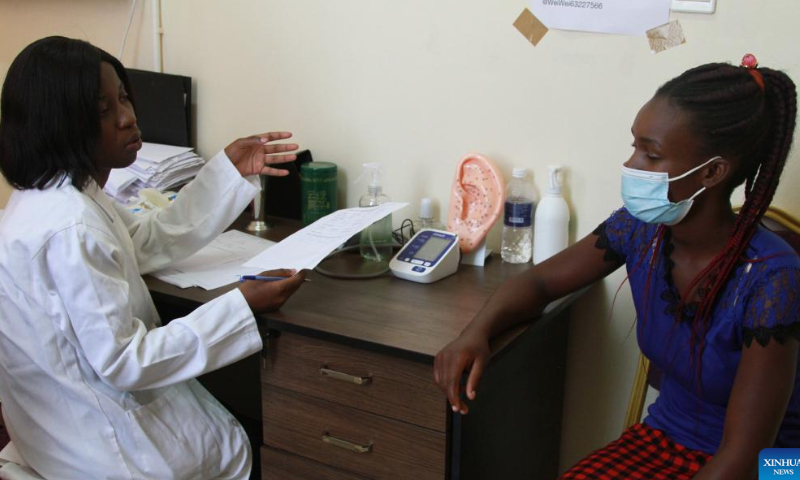 Tatenda Chimbunde (L) interacts with a patient at the Zimbabwe-China Traditional Chinese Medicine (TCM) and Acupuncture Center in Harare, Zimbabwe on Jan. 18, 2023. Photo: Xinhua
