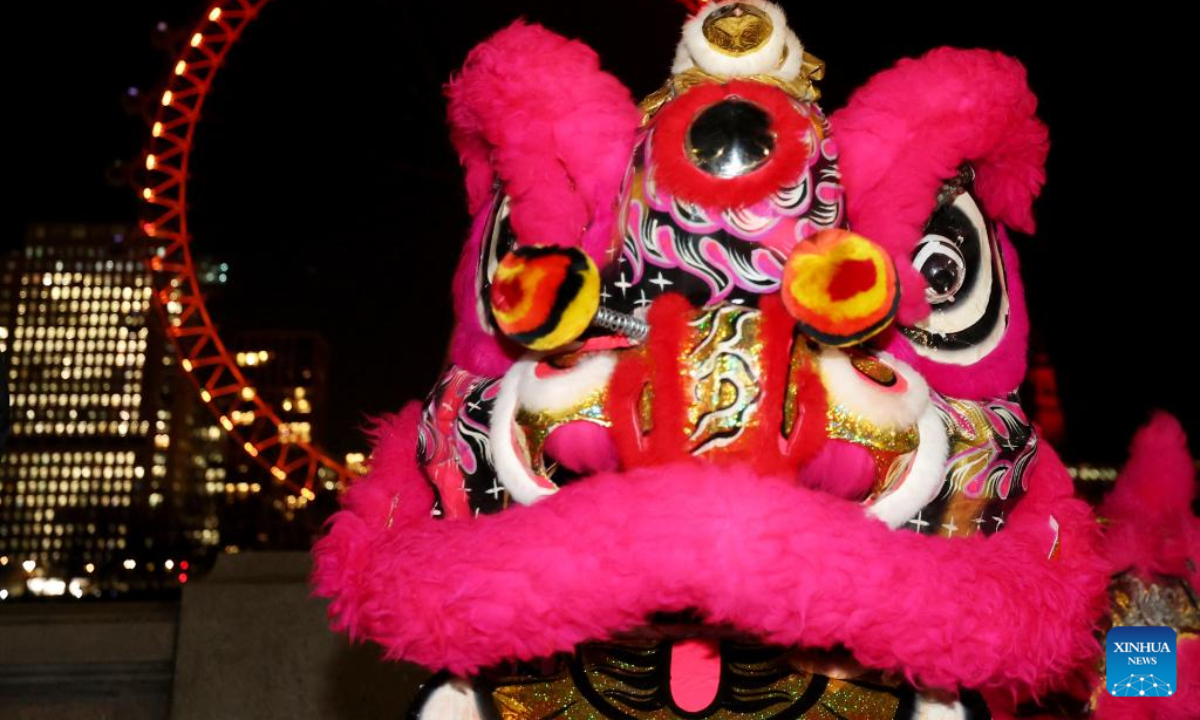 Traditional Chinese lion dancers perform in front of the London Eye which is lit up in red to celebrate the upcoming Chinese New Year in London, Britain, Jan 13, 2023. Photo:Xinhua