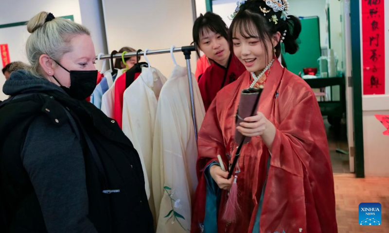 A visitor learns about the history of Hanfu, traditional Chinese clothing, at the Lunar New Year Market hosted by University of British Columbia (UBC) Botanical Garden in Vancouver, British Columbia, Canada, on Jan. 14, 2023. (Photo by Liang Sen/Xinhua)