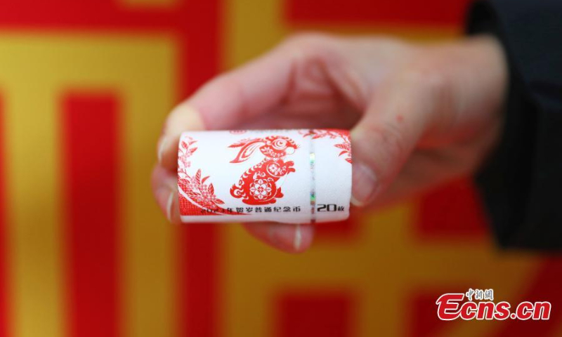 A staff member displays a set of commemorative coins for the Year of the Rabbit in the Jiangxi branch of Postal Saving Bank of China in Nanchang, east China's Jiangxi Province, Jan. 5, 2023. (Photo: China News Service/Liu Zhankun)