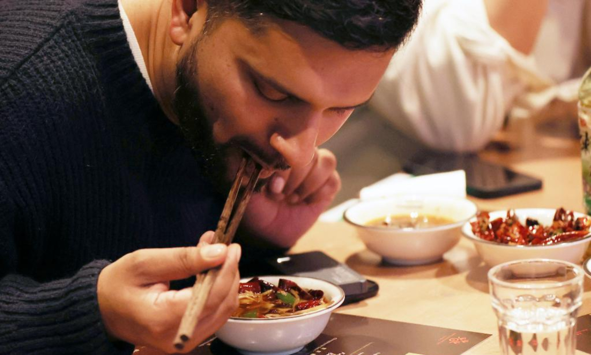 A man tastes boiled spicy fish fillet during