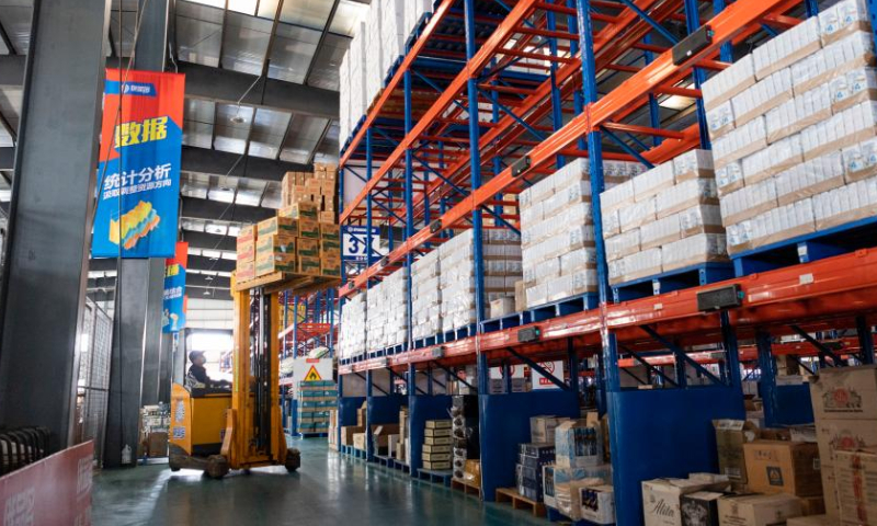 An employee carries goods at the intelligent warehouse and logistics center of Heihe cross-border e-commerce industrial park in the Heihe Area of China (Heilongjiang) Pilot Free Trade Zone in northeast China's Heilongjiang Province, Feb. 11, 2023. Recently, enterprises in the Heihe Area of China (Heilongjiang) Pilot Free Trade Zone have been busy with production to meet the orders and to make a good start in the first quarter of 2023. Photo: Xinhua