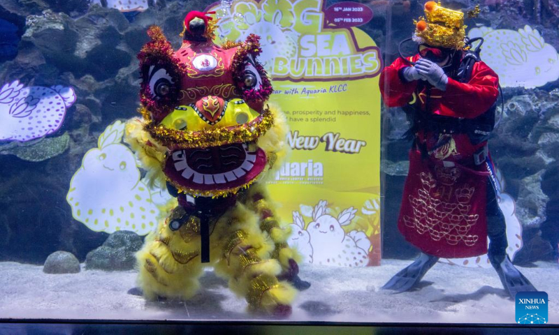 Divers dressed as a lion and a Fortune God stage an underwater performance in celebration of the Lunar New Year at Aquaria KLCC in Kuala Lumpur, Malaysia, Jan. 18, 2023. (Xinhua/Zhu Wei)