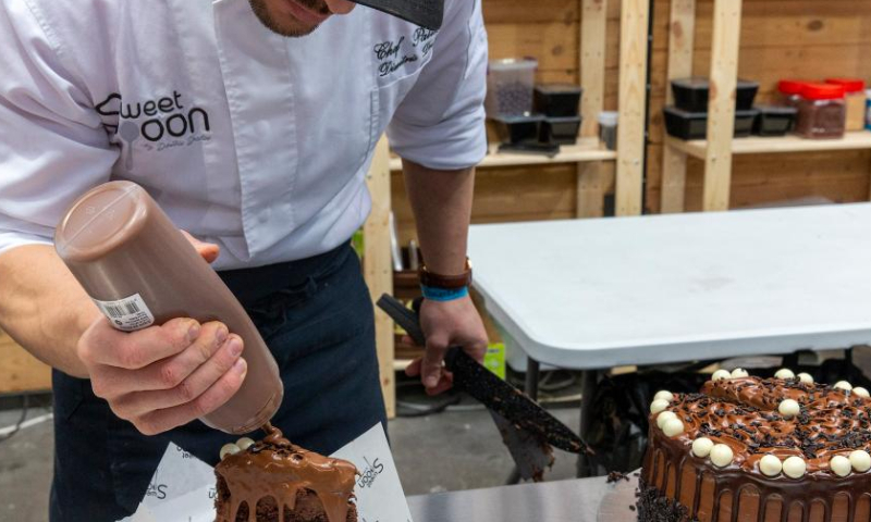 A pastry chef prepares a slice of a chocolate cake at the 4th Chocolate Fest in Athens, Greece, Feb. 11, 2023. Photo: Xinhua