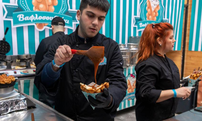 An employee of a pastry shop prepares a chocolate waffle at the 4th Chocolate Fest in Athens, Greece, Feb. 11, 2023. Photo: Xinhua