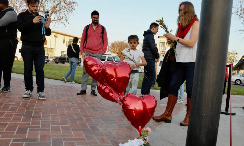 People mourn for victims of a mass shooting in front of the city hall of Monterey Park, California, the United States, Jan. 22, 2023. Five women and five men were killed while another 10 people were injured in a mass shooting in the city of Monterey Park, 16 km east of Los Angeles downtown, the authorities said Sunday. (Xinhua)