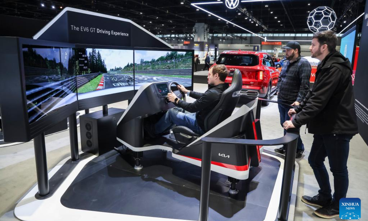 Journalists try out a virtual race in a KIA EV6 during the media preview of Chicago Auto Show in Chicago, the United States, Feb 9, 2023. Photo:Xinhua