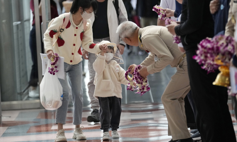 A Thai official gives a garland to Chinese tourists as they arrive at Suvarnabhumi International Airport in Samut Prakarn province, Thailand, on January 9, 2023. Photo: VCG