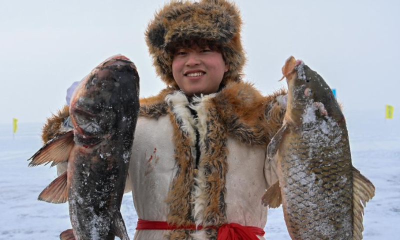 A young man shows fish during a winter fishing tourism festival in Fuhai County, northwest China's Xinjiang Uygur Autonomous Region, Jan. 7, 2023. Xinjiang, which boasts favorable natural conditions and multiple high-standard ski resorts, has taken the starring role in the booming industry to become one of the country's most popular winter tourism destinations. Photo: Xinhua