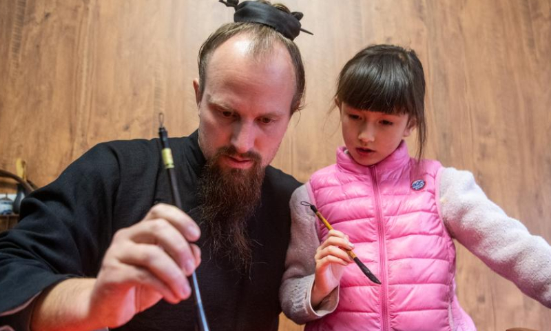 Jake Lee Pinnick writes Spring Festival couplets with his daughter at his home in Danjiangkou, central China's Hubei Province, Jan. 12, 2023. Photo: Xinhua