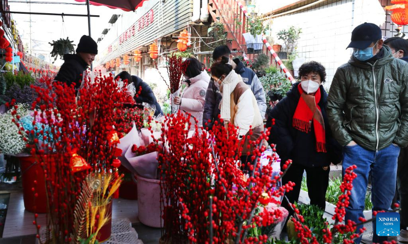 People buy flowers for the Spring Festival at a market in Xuhui District of east China's Shanghai Jan. 18, 2023. This year's Spring Festival, the Chinese traditional lunar New Year, starts from Jan. 22. (Xinhua/Fang Zhe)