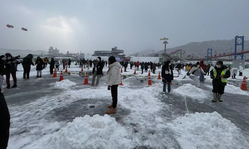 Tourists stand on ice and snatch fish with bare hands at Hwacheon Sancheoneo Ice Festival in Hwacheon, South Korea, on Jan. 7, 2023. Themed Never freezing warm-heartedness, never melting memories, the Hwacheon Sancheoneo Ice Festival has attracted 130,000 local and foreign tourists to fish on top of the ice in Hwacheon county, and participants are allowed to take up to three fish they caught back home. (Xinhua/Sun Yiran)

