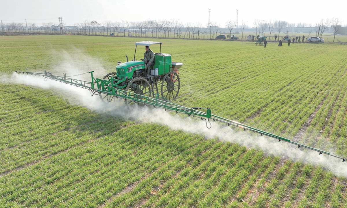 People drive a self-propelled high-pole sprayer to spray wheat in the fields of Gaotang village, East China's Anhui Province, on January 8, 2023. In the midst of the critical period of wheat field management, local farmers are using plant protection drones and large-scale agricultural plant protection machinery to carry out chemical weeding and pest control to ensure the success of the harvest. Photo: cnsphoto