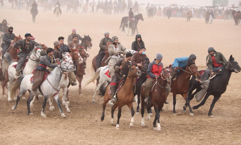 Afghan horse riders compete in a Buzkashi game in Balkh province, Afghanistan, Jan. 6, 2023. Buzkashi, or goat grabbing, is a kind of traditional sport in Afghanistan. In this game, two teams of horsemen compete to grab a goat carcass and carry it through a goal. (Photo by M Fardin Nawrozi/Xinhua)