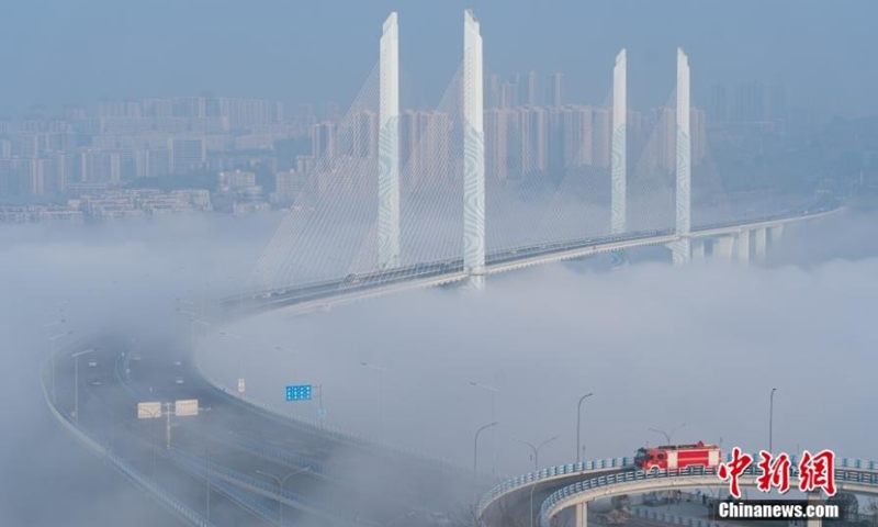 A metro train runs in advection fog shrouded Caijia Rail Transit Bridge in Chongqing, creating an amazing scenery of train running over the could, Jan. 7, 2023. (Photo provided to China News Service)