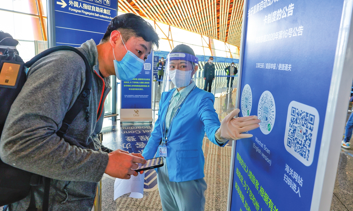 An airport employee guides an arriving passenger to complete online declaration at the Beijing Capital International Airport on January 8, 2023. Photo: Li Hao/GT