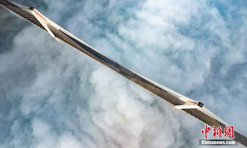 A metro train runs in advection fog shrouded Caijia Rail Transit Bridge in Chongqing, creating an amazing scenery of train running over the could, Jan. 7, 2023. (Photo provided to China News Service)