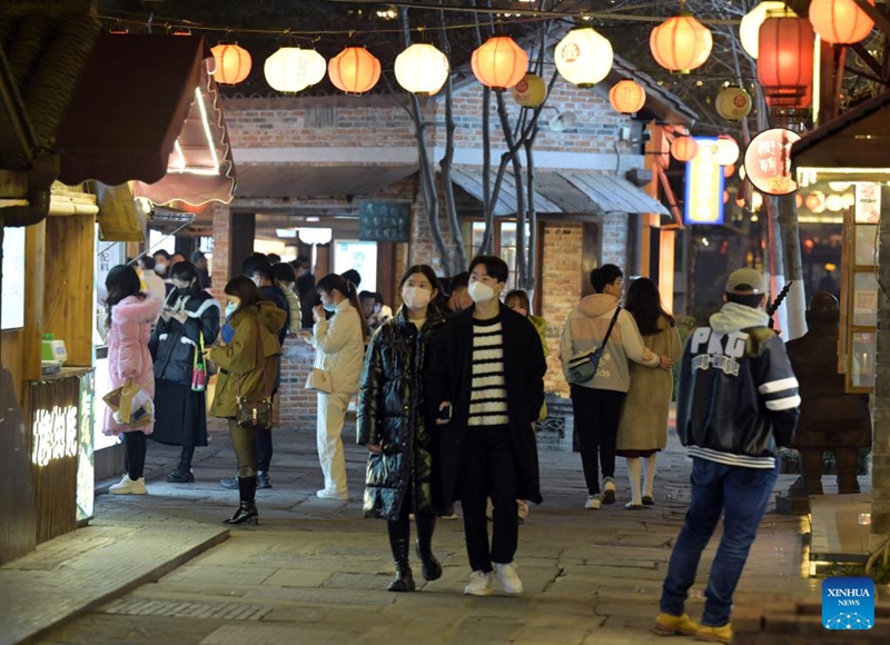 People walk on Leijie street, a commercial area famous for its night economy, in Hefei, east China's Anhui Province, Jan. 6, 2023. The night-time consumption in the commercial area has resumed in an orderly manner recently. (Xinhua/Zhou Mu)