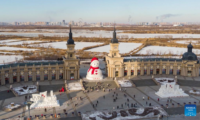 This aerial photo taken on Jan. 14, 2023 shows a giant snowman in Harbin, northeast China's Heilongjiang Province. Harbin is famous for its rich ice and snow resources. This winter, the city opened three ice and snow-themed parks, launched 12 ice and snow experience products and 10 such tourism routes, and created more than 100 related activities to promote the development of winter tourism, culture, fashion and sports. (Xinhua/Xie Jianfei)